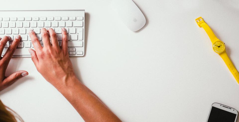 Hands typing on a laptop keyboard